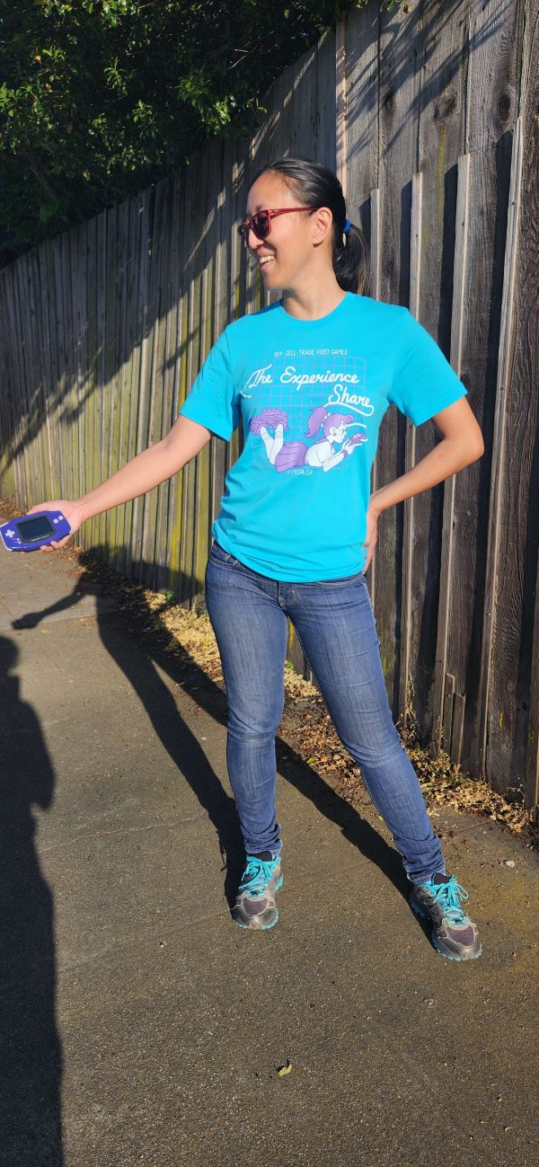Judy models Experience Share merch! She wears a blue t-shirt with our logo in white and purple.